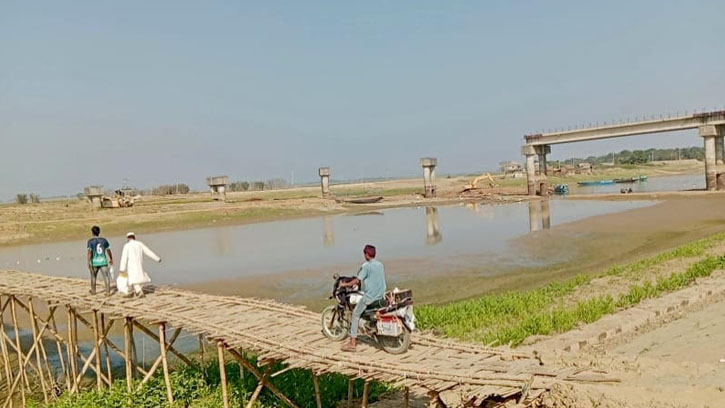 মধ্যনগরে নদী পারাপারে বাঁশের চাটাই ভরসা, সেতুর কাজ বন্ধ 